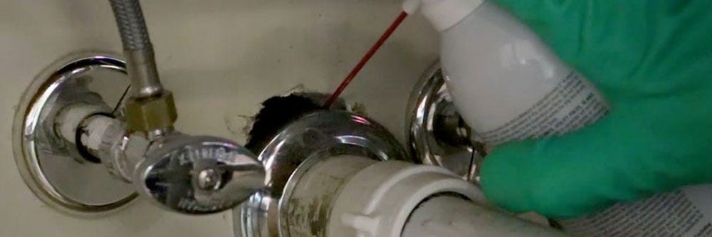 Spraying Fipro Foaming Aerosol in sink void