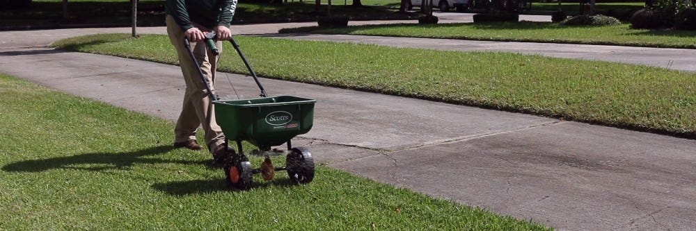 Fertilizer spreader being used on lawn
